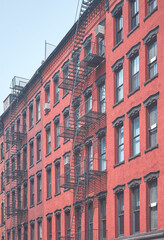 Altes Backsteingebäude mit eiserner Feuerleiter, Farbtonung angewendet, New York City, USA.