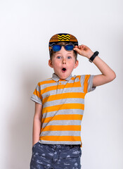 Portrait of cool stylish little boy wearing sunglasses smirking. Kid in shades leaning on a blackboard looking at camera smiling with copy space.