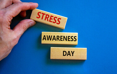 Stress awareness day symbol. Wooden blocks with words 'Stress awareness day'. Beautiful blue...