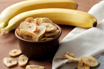 Composition with sweet dried banana slices, fresh bananas. Top view with space for text. Dried fruit as healthy snack. Healthy breakfast