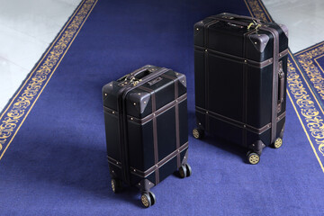 Two suitcases with luggage are on the carpet in hotel. Comfortable modern luggage. Blue carpet. Top view. The holiday season. Free space.