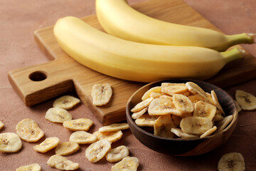 Composition with sweet dried banana slices, fresh bananas. Top view with space for text. Dried fruit as healthy snack. Healthy breakfast