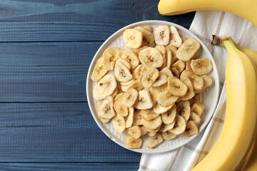 Composition with sweet dried banana slices, fresh bananas on a blue wooden  background. Dried fruit as healthy snack