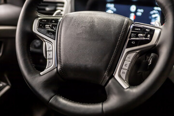 Multifunctional leather steering wheel in black in a modern car.