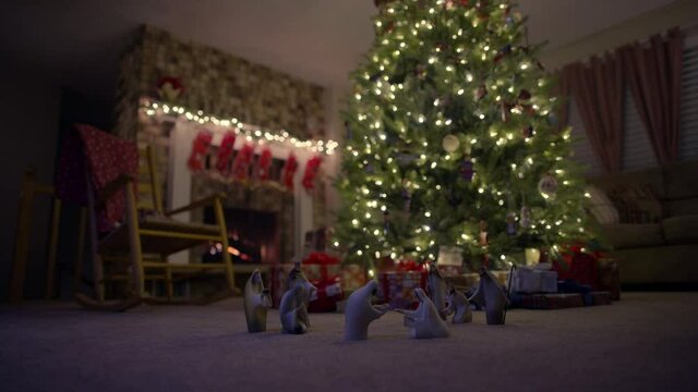 Nativity figurines in living room floor near Christmas tree, low angle