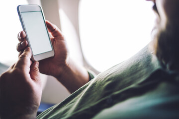 Man messaging on smartphone in plane