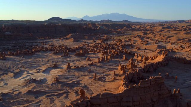 Wide aerial, open desert landscape at sunset in Goblin Valley