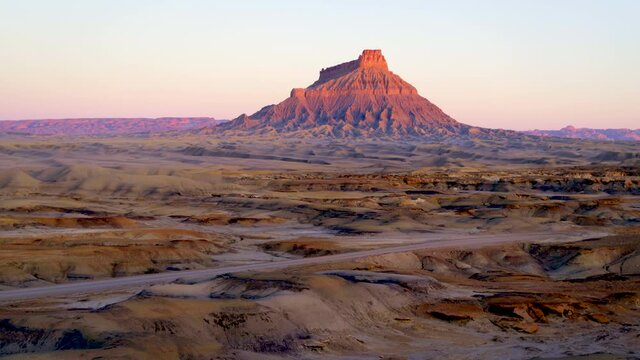 Tall mountain in Goblin Valley State Park at sunset, wide aerial