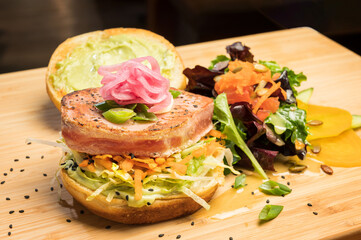 Asian tuna Sandwich at a diner.  Grilled yellowfin tuna, Citrus slaw, Asian tzatziki, and pickled onion.