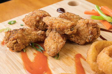 Chicken wings and onion rings with a pitcher of beer.