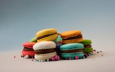Multicolored macarons with beads on a gray background.