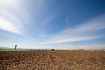 tractor sowing of seed to field at spring time