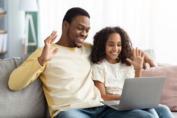 Black father and daughter having video conference from home