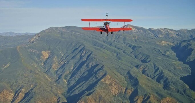 Wide aerial, vintage planes flies over mountain range