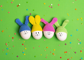 Creative Easter idea. Four easter decorative eggs with painted cheerful faces and crocheted ears in...