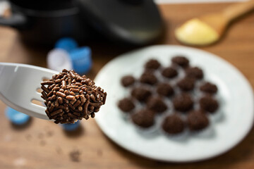 Tradicional Brazilian Snack Brigadeiro on a plate on a wooden background