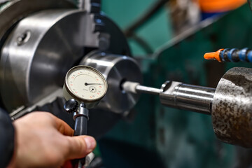 The worker measures the ground hole with an internal gage.