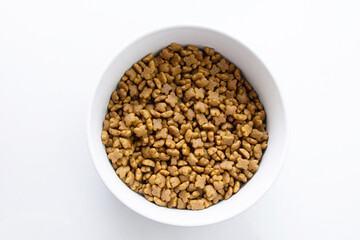 Dog and cat dry food in a white bowl. Isolated on white background