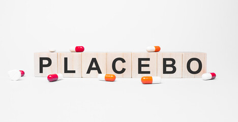 PLACEBO the word on wooden cubes, cubes stand on a reflective white surface. Medicine concept