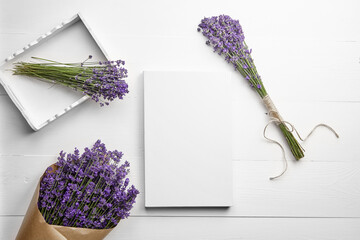 White canvas mockup and lavender flowers bouquet on white wooden table background, flat lay