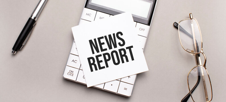 pen, calculator and glasses on grey background. Business concept. White paper sheet with News Report sign