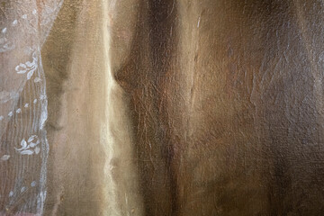 Close-up fragment of oil painting on canvas in brown tones. The structure of the canvas, paint strokes and cracks from old age are visible.