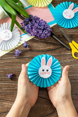 Child is holding an Funny paper easter bunny. Easter handmade Project of children's creativity, handicrafts, crafts for kids.