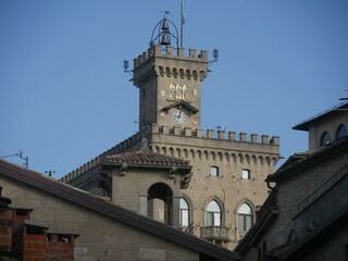 Fototapeta na wymiar San Marino - Public Palace with the crenellated clock tower, the mosaic and the coats of arms of the four castles