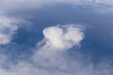 Stratosphere, a view of clouds from an airplane window.  Cumuliform cloudscape on sky. Flying over the land.