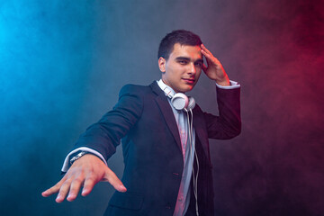 Portrait of man with headphones on dark background with smoke. Studio shoot