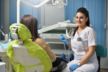 Portrait of a woman dentist while working with a patient.