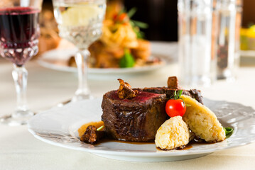 beautiful fried medium fried steak with porridge garnish and fried chanterelle and pmidora mushroom decorations