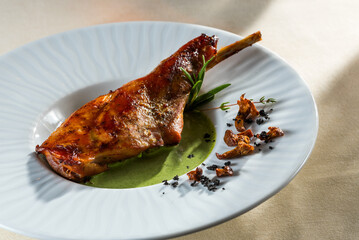 fried duck leg with cream spinach soup on a platter in a restaurant