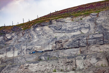 Rudny/Kazakhstan - May 14 2012:  Open-pit mining iron ore. Railway train and diesel locomotive down in quarry transporting ore to concentrating plant. Mineral rocks on background.