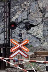 Rudny/Kazakhstan - May 14 2012:  Open-pit mining iron ore. Railway down in quarry and road sign and red stop light on cross. Minerals rocks on background.