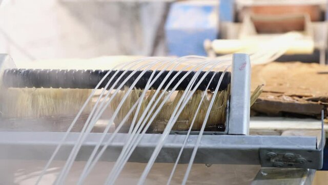 Plastic strands go to strand cutter to recycle plastic and create pellets from pellet mill after hydrocooling with water, industrial concept, recyclable, and pellets for recycling plastic