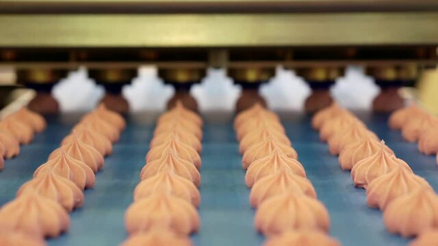 Moving confectionery close-up on a conveyor line. Shallow depth of field. Selective focus.