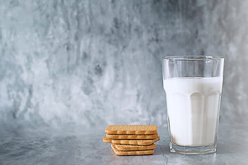 A glass of kefir and cookies on textured gray background. Selective focus.
