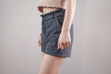  Young caucasian woman in fashion shorts at home.