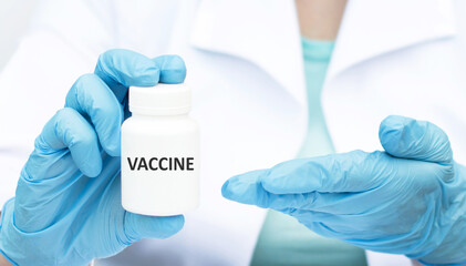Obraz premium The vaccine is written on a white jar in the hands of a doctor. Bolra with covid-19