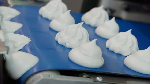 Moving confectionery on a conveyor line close-up.