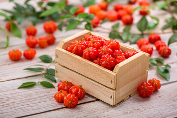 Suriname cherries in a small wooden box on a wooden surface.