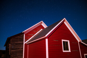 Red barn lit up against the night sky