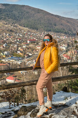 woman traveler in sportswear, yellow jacket and sunglasses