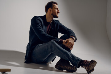 Fashion business man model posing in the studio. Confident male weared casual suit.