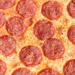 Pepperoni pizza with salami sausage and melted cheese, super close up shot. Food background or texture. Soft Focus.
