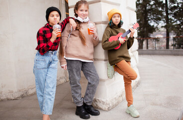 Group of kids walking outdoor in the street, playing guitar and sing siong