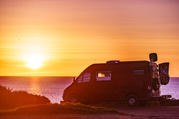 Camper van on beach at sunrise