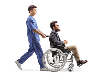 Full length profile shot of a young male nurse pushing a man in a wheelchair