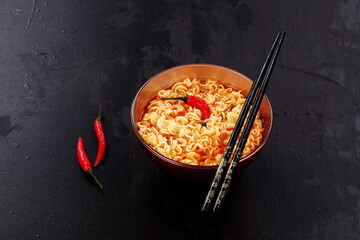 Chinese noodles with red pepper on black background